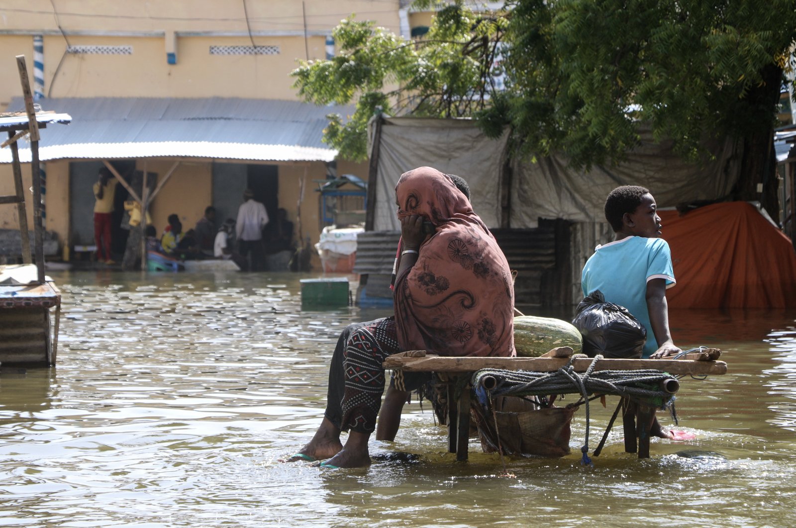 Residents sit on a cart amidst the floodwater at a submerged street in Beledweyne, Hiran region, central Somalia, Nov. 20, 2023. (EPA Photo)