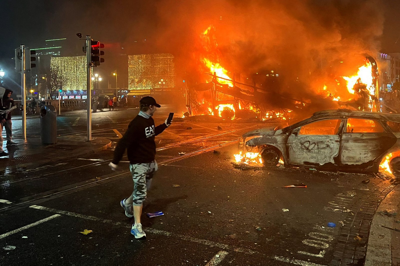 Flames rise from a car and a bus, set alight at the junction of Bachelors Walk and the O&#039;Connell Bridge, Dublin, Ireland, Nov. 23, 2023. (AFP Photo)