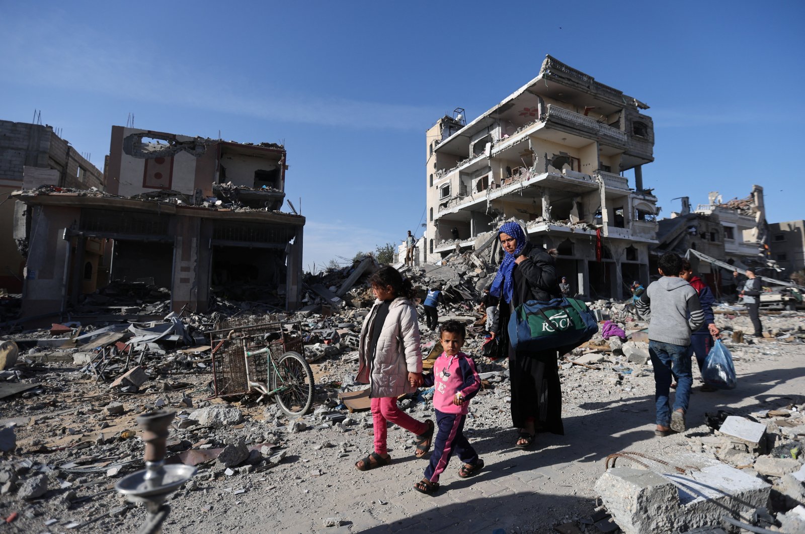 Displaced Palestinians return to their homes as they walk near houses destroyed in an Israeli strike during the conflict, amid the temporary truce between Hamas and Israel, in Khan Younis in the southern Gaza Strip, Nov. 24, 2023. (Reuters Photo)
