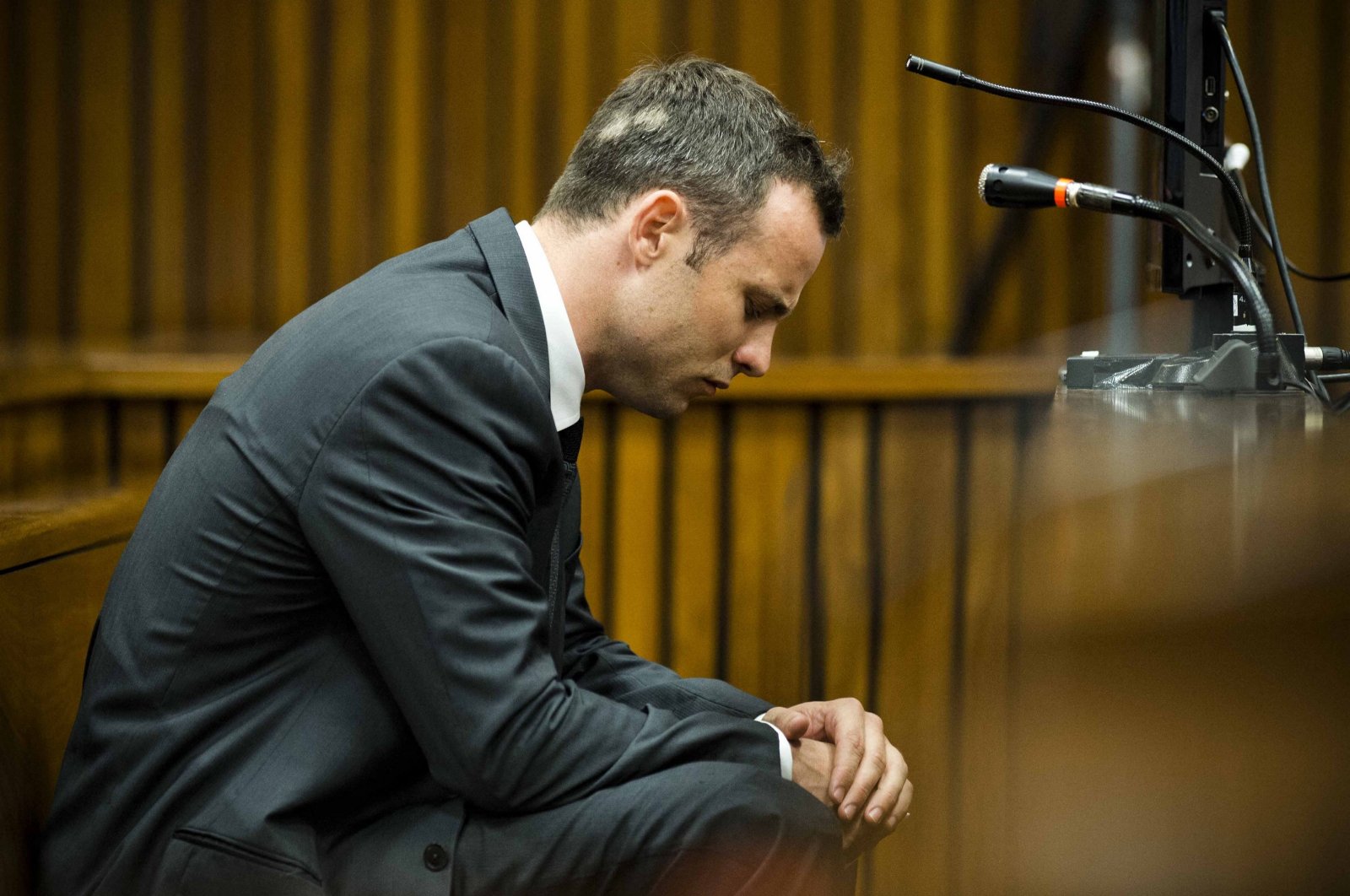 South African paralympic athlete Oscar Pistorius sits on the fifth day of his trial for the 2013 murder of his girlfriend, Pretoria, South Africa, March 7, 2014. (AFP Photo)