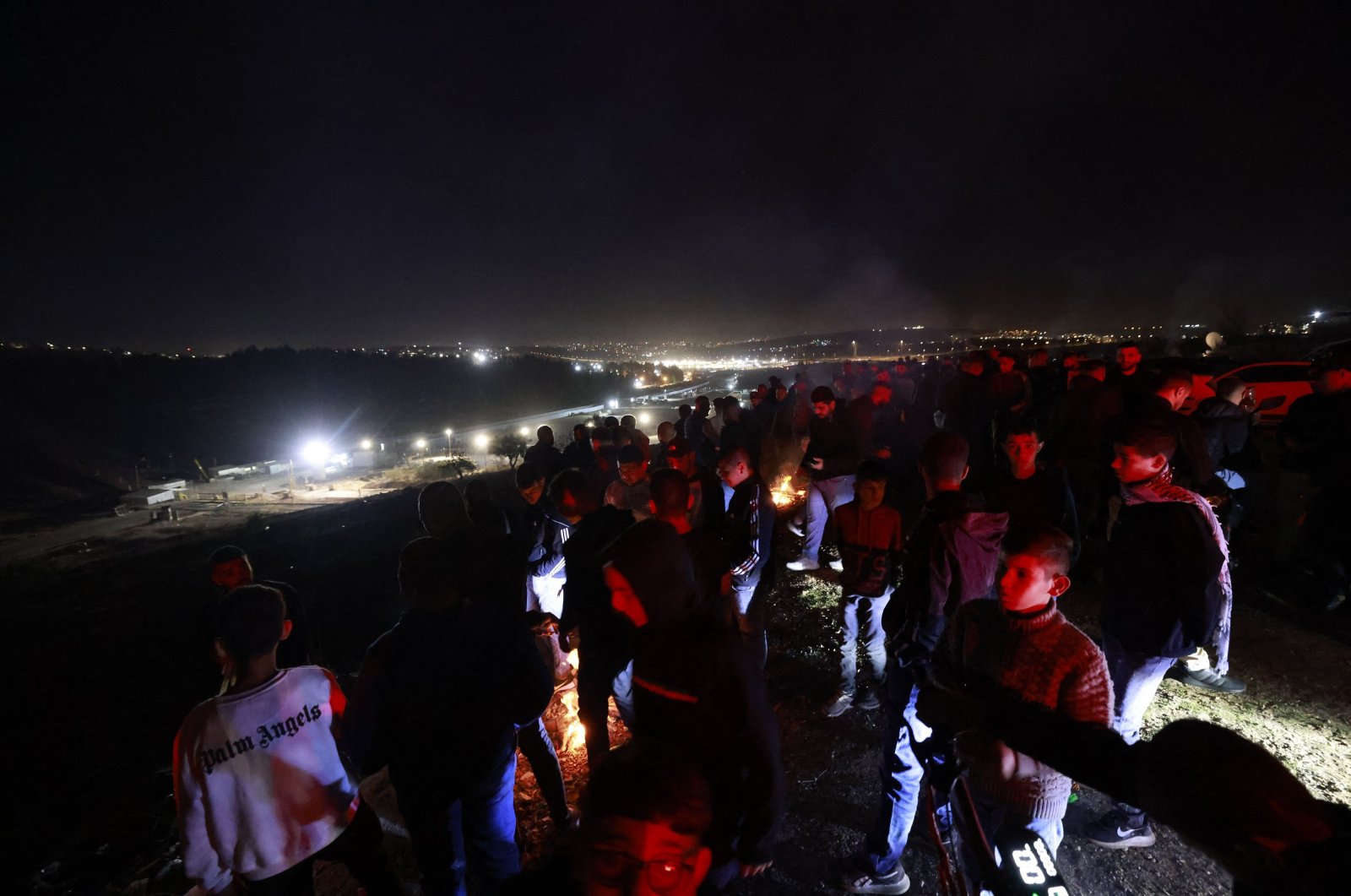 People gather on a hill overlooking the Israeli Ofer military facility in Baytunia in the occupied West Bank as they wait for the release of Palestinian prisoners in exchange for Israeli hostages freed by Hamas in Gaza on Nov. 24, 2023. (AFP Photo)