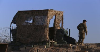 A PKK/YPG terrorist stands inside a post where U.S. troops were based, in Tel Abyad, Syria, Oct. 7, 2019. (AP Photo)