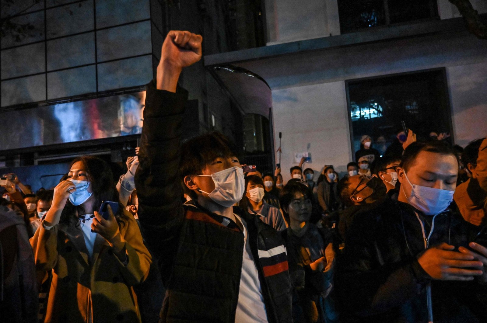 People sing slogans while gathering on a street in Shanghai, China, Nov. 27, 2022. (AFP Photo)