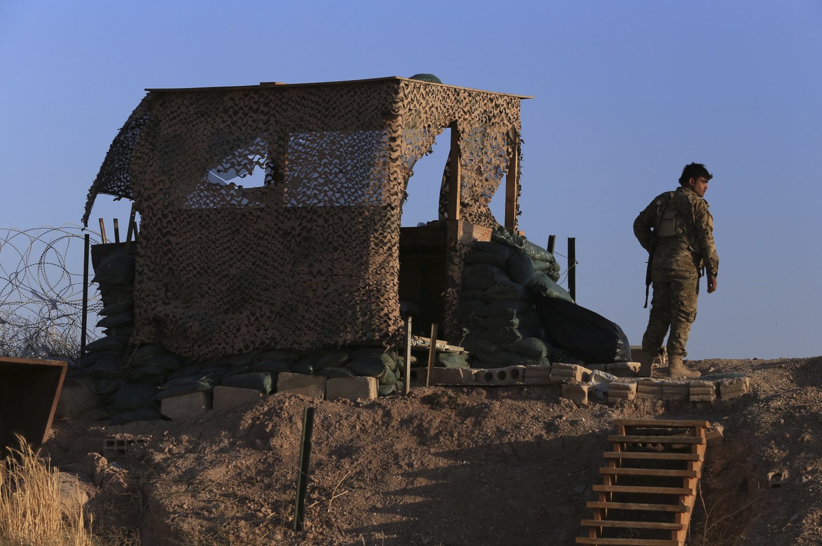 A PKK/YPG terrorist stands inside a post where U.S. troops were based, in Tel Abyad, Syria, Oct. 7, 2019. (AP Photo)