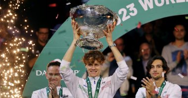 Italy's Jannik Sinner celebrates with the trophy and teammates after winning the Davis Cup Tennis following the Australia match at the Palacio de deportes Martin Carpena, Malaga, Spain, Nov. 26, 2023. (Reuters Photo) 