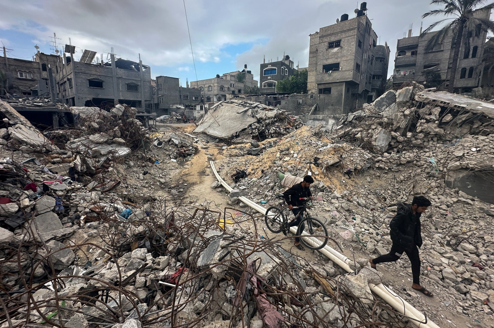 Palestinians walk among the rubble as they inspect houses destroyed in Israeli strikes in Khan Younis, southern Gaza, Palestine, Nov. 27, 2023. (Reuters Photo)