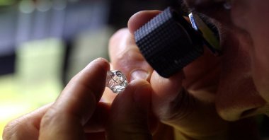 An employee looks at a rough diamond at &quot;Flanders Manufacturing&quot;, as the G-7 weighs a ban on Russian diamond imports to reduce revenues for Moscow&#039;s war in Ukraine, Antwerp, Belgium, Oct. 30, 2023. (Reuters Photo)