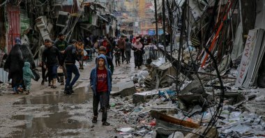 Palestinians walk amid debris of buildings hit in Israeli strikes near al-Zawiya market on the fourth day of a truce in fighting between Israel and Hamas, Gaza City, Palestine, Nov.27, 2023. (AFP Photo)