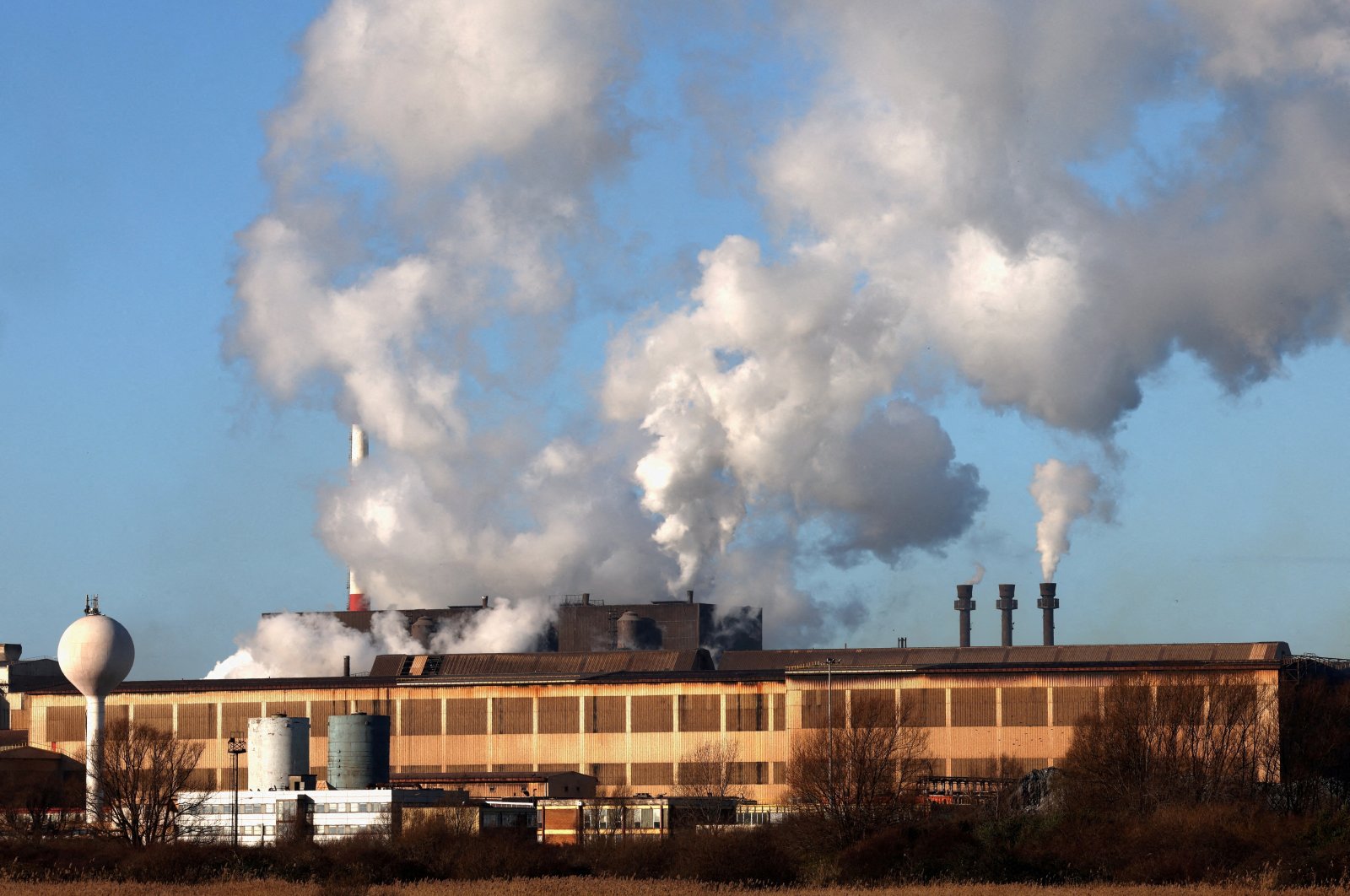 Smoke rises from chimneys at a factory in the port of Dunkirk, France, Jan. 19, 2023. (Reuters Photo)