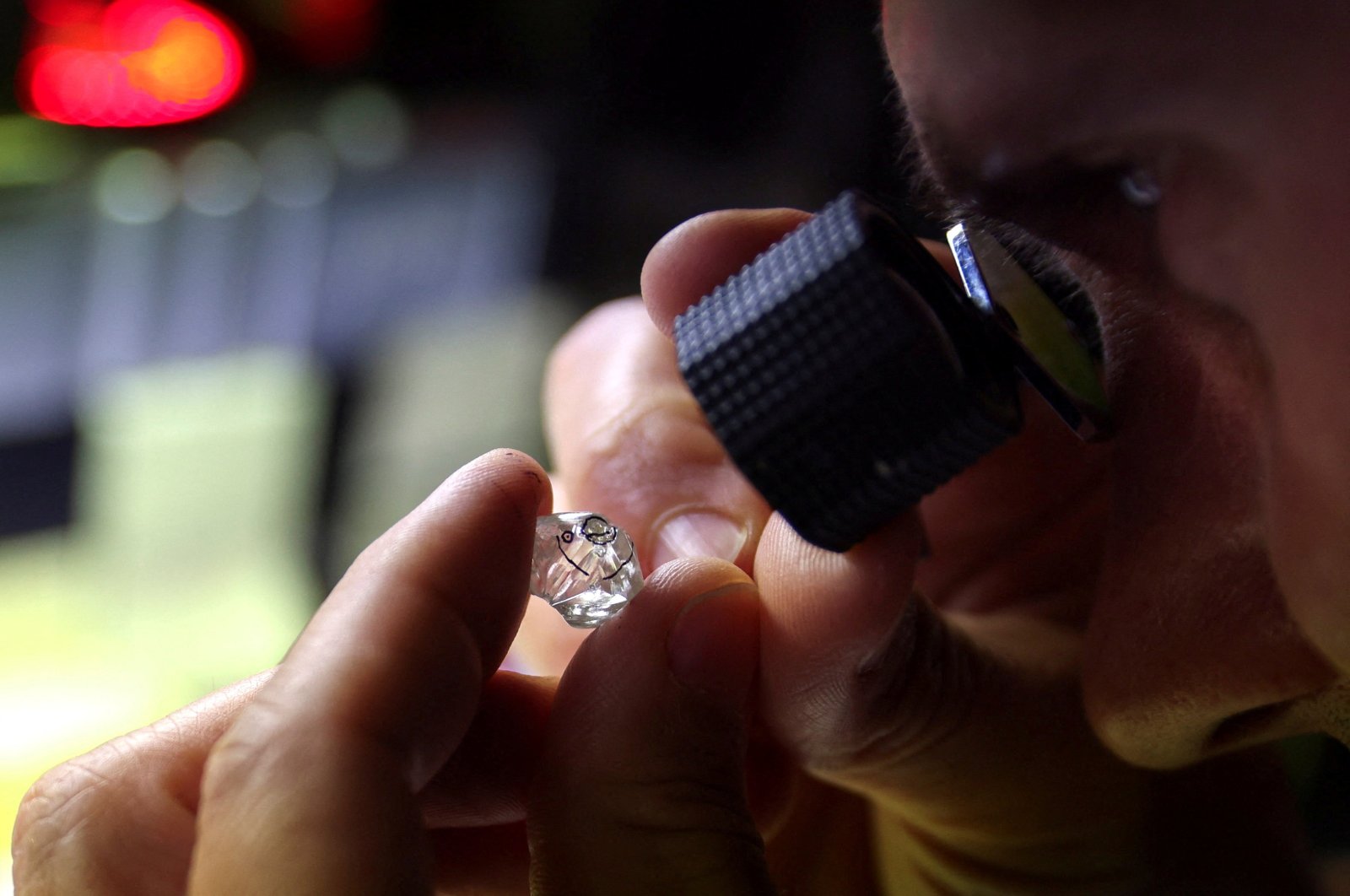 An employee looks at a rough diamond at &quot;Flanders Manufacturing&quot;, as the G-7 weighs a ban on Russian diamond imports to reduce revenues for Moscow&#039;s war in Ukraine, Antwerp, Belgium, Oct. 30, 2023. (Reuters Photo)