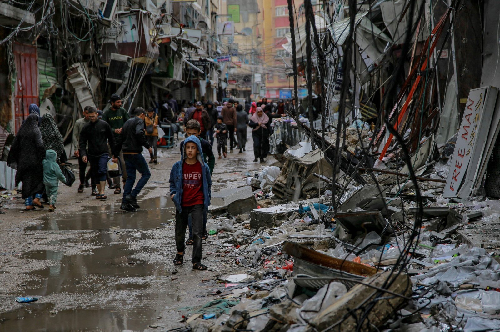 Palestinians walk amid debris of buildings hit in Israeli strikes near al-Zawiya market on the fourth day of a truce in fighting between Israel and Hamas, Gaza City, Palestine, Nov.27, 2023. (AFP Photo)