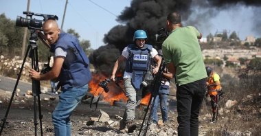 In this undated photo, Palestinian journalists cover an Israeli attack at a location in Gaza, Palestine. (AA Photo)