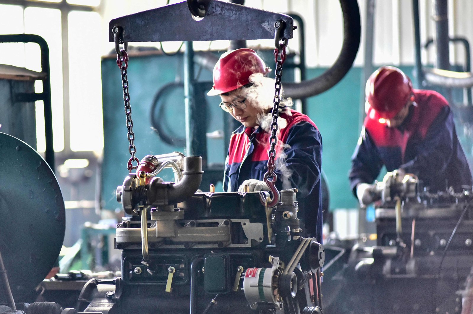 Employees work on engines at a factory in Qingzhou, in eastern Shandong province, China, Nov. 30, 2023. (AFP Photo)