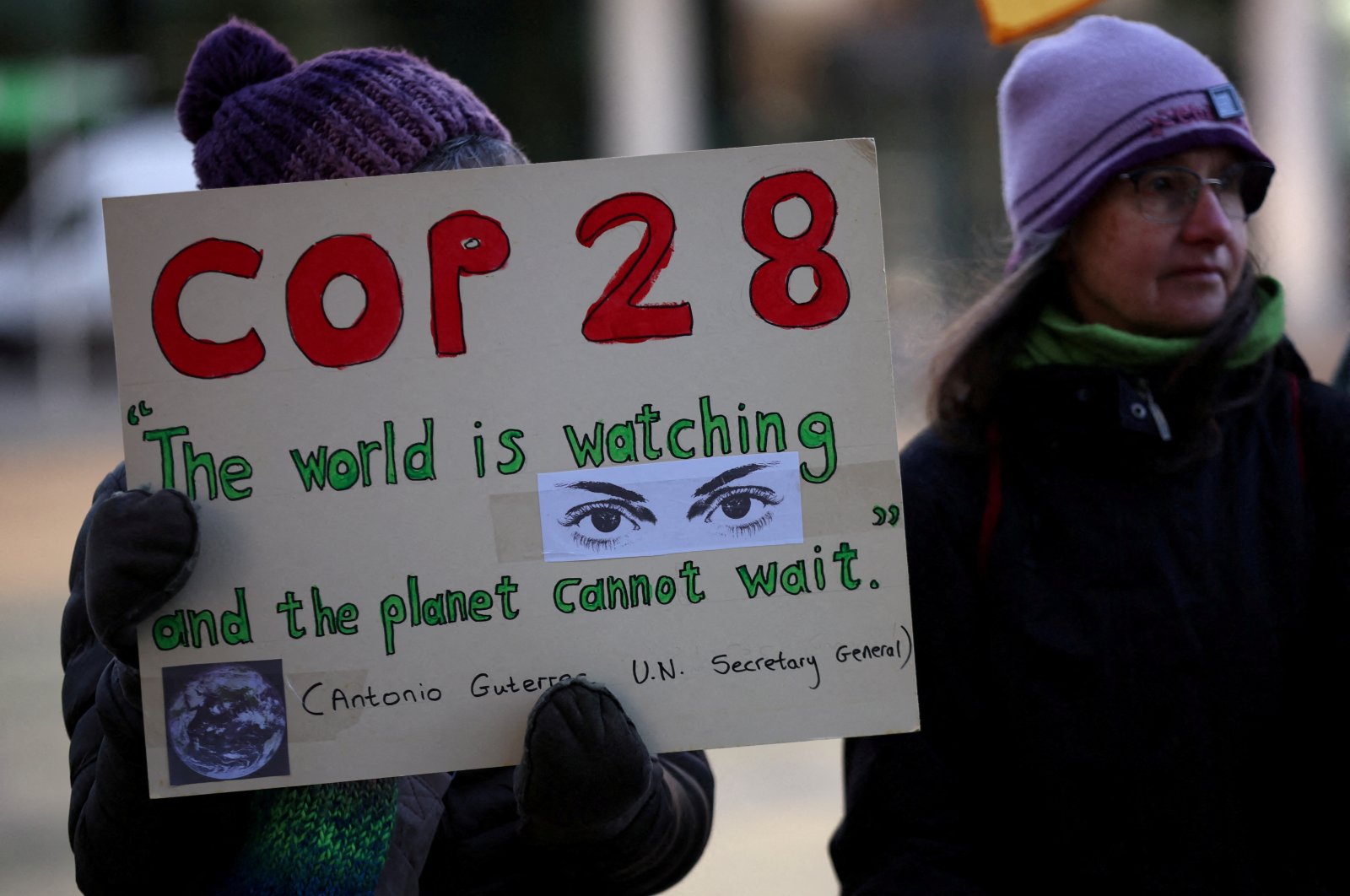 A climate activist holds a placard during a vigil to mark the opening day of the COP28 summit outside the offices of the BBC in Salford, Britain, Nov. 30, 2023. (Reuters Photo)