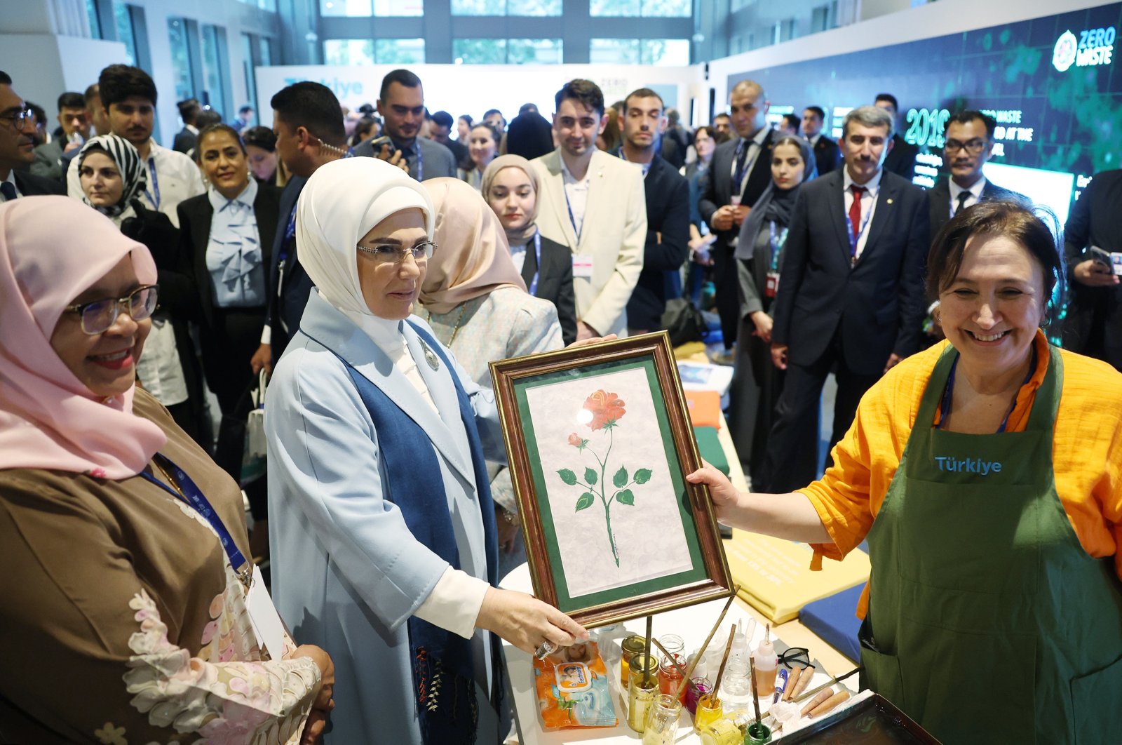 Türkiye’s first lady Emine Erdoğan poses with a paper marbling portrait made by a climate volunteer as she visits the Türkiye Pavilion at the Expo City Dubai, United Arab Emirates, Dec. 1, 2023. (AA Photo)