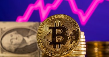 A representation of the cryptocurrency bitcoin is seen in front of a stock graph and U.S. dollar in this illustration taken, Jan. 24, 2022. (Reuters Photo)