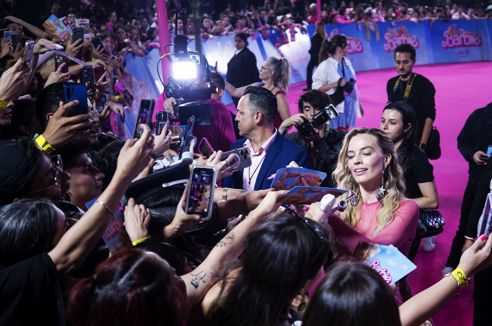 Australian actor Margot Robbie (R) signs autographs during the pink carpet event for the movie &quot;Barbie,&quot; at Parque Toreo Central, in Mexico City, Mexico, July 6, 2023. (EPA Photo)