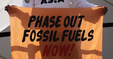 A person holds a sign reading "phase out fossil fuels now!" during a demonstration for a just and equitable transition from fossil fuels at the COP28 U.N. Climate Summit, Dubai, United Arab Emirates (UAE), Dec. 5, 2023. (AP Photo)
