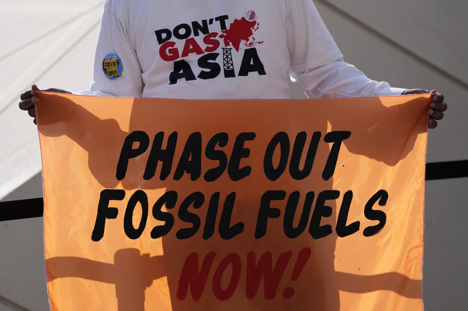 A person holds a sign reading &quot;phase out fossil fuels now!&quot; during a demonstration for a just and equitable transition from fossil fuels at the COP28 U.N. Climate Summit, Dubai, United Arab Emirates (UAE), Dec. 5, 2023. (AP Photo)