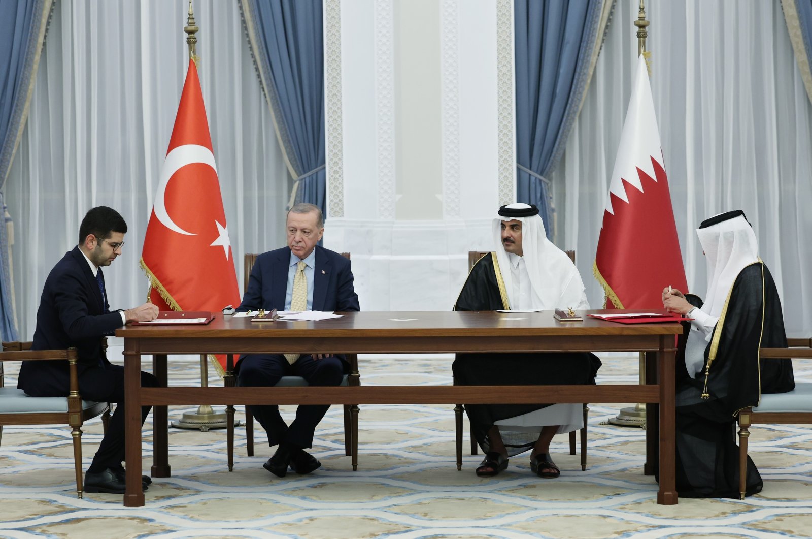 President Recep Tayyip Erdoğan (3rd R) and Qatari Emir Sheikh Tamim bin Hamad Al Thani (2nd R) are photographed during the signing ceremony of the agreements between the two countries, Doha, Qatar, Dec. 4, 2023. (IHA Photo)