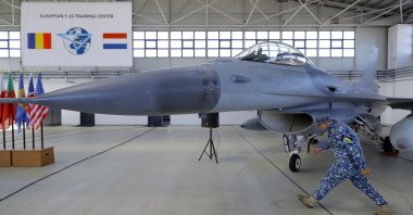 A Romanian Air Force military soldier passes an F15 Falcon jet airplane before the opening ceremony for the European F-16 Training Center, held at the 86th Air Base, Borcea, Romania, Nov. 13, 2023. (EPA Photo)