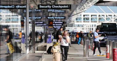 A woman passes below a sign for a security checkpoint at Los Angeles International Airport (LAX) ahead of the Thanksgiving holiday, Los Angeles, California, U.S., Nov. 22, 2023. (AFP Photo)
