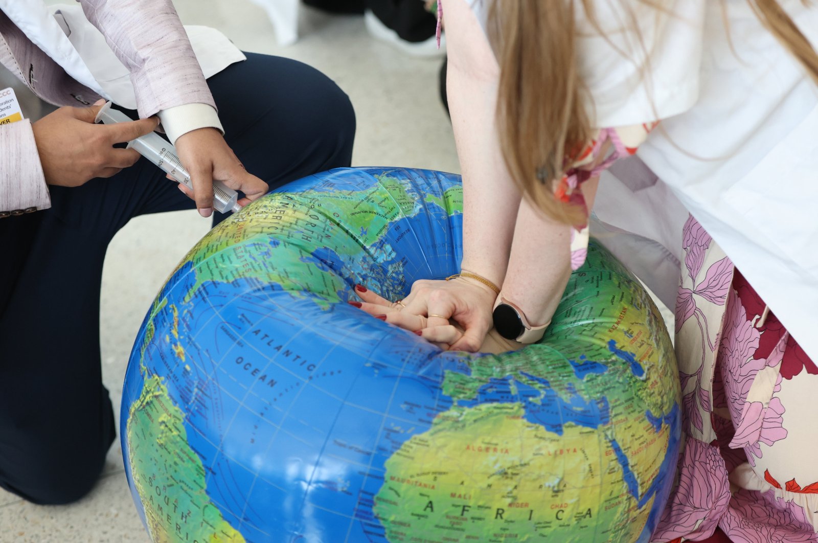 Activists perform CPR on an inflated globe model during a protest &quot;End Fossil Fuel now! Climate Crisis = Health Crisis&quot; during the U.N. Climate Change Conference (COP28), Dubai, UAE, Dec. 6, 2023. (EPA Photo)