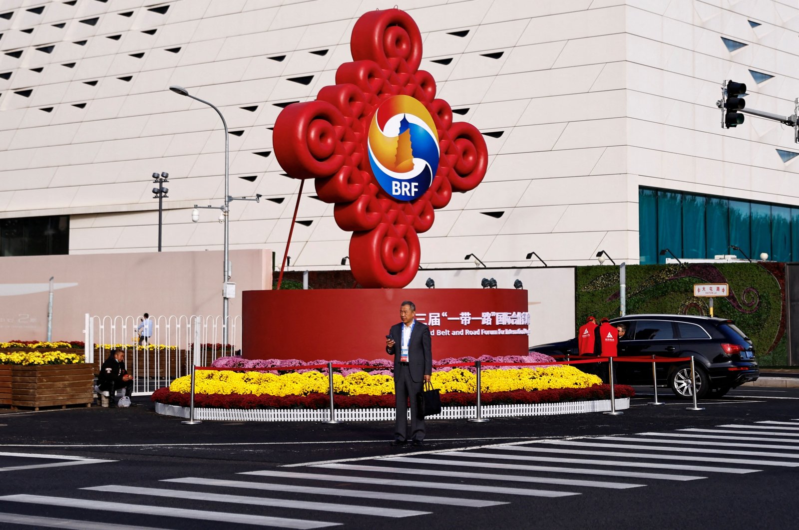 A person stands in front of a sign of the Third Belt and Road Forum ahead of its opening ceremony, near the media center in Beijing, China, Oct. 18, 2023. (Reuters Photo)