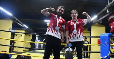 Turkish kickboxers Emre Karaca (L) and Güler Deniz Topuz pose with a trophy, Darıca, Türkiye, Nov. 30, 2023. (AA Photo)