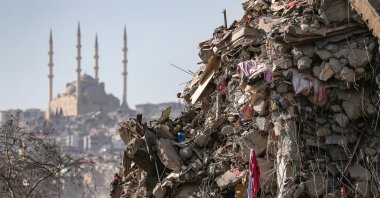 A collapsed building with Abdülhamid Han Mosque in the background after a powerful earthquake in Kahramanmaraş, Türkiye, Feb. 18, 2023. (EPA Photo)