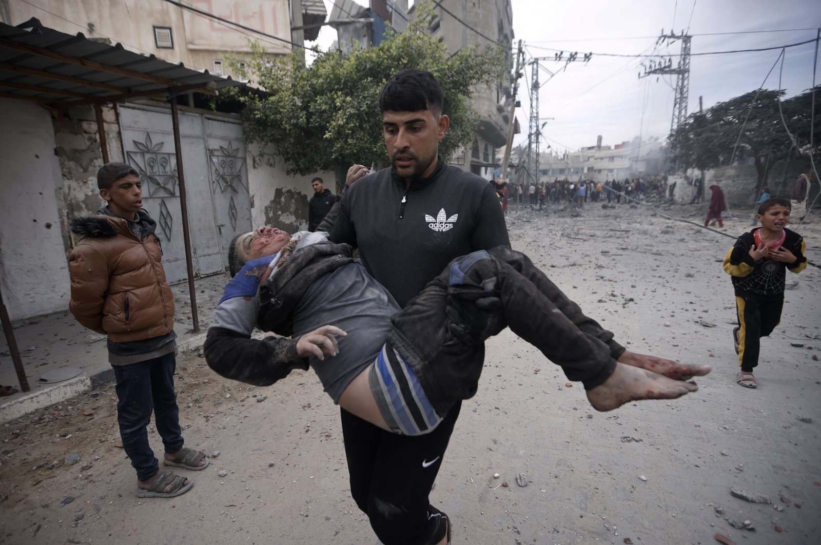 A Palestinian man evacuates a wounded boy following Israeli airstrikes in Khan Younis refugee camp, southern Gaza Strip, Dec. 7, 2023. (AP Photo)