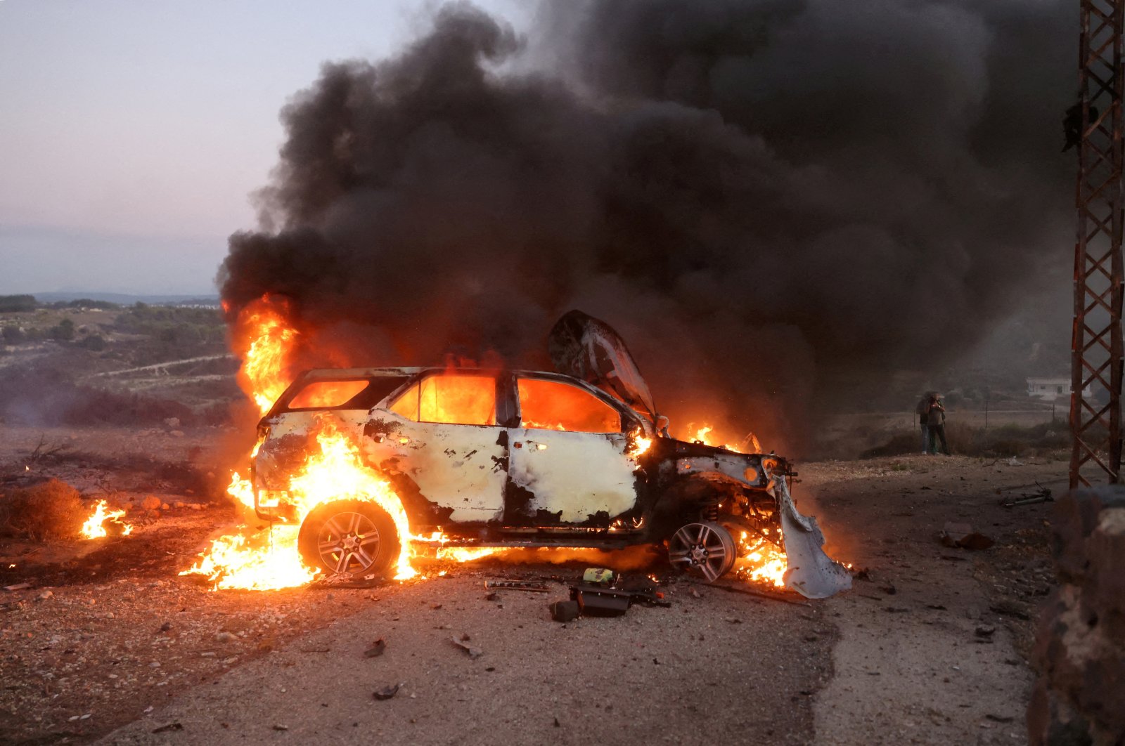 A car belonging to an Al Jazeera team burns at the site where Reuters visuals journalist Issam Abdallah was killed and six others were wounded by two tank rounds fired from Israel, Alma al-Chaab, near the border with Israel, southern Lebanon, Oct.13, 2023. (Reuters Photo)