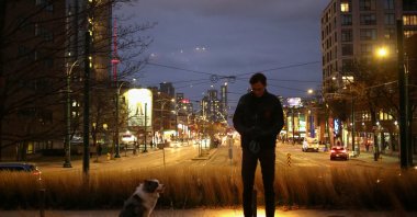 Justinas Stankus, 38, who came to Canada from Lithuania in 2019 and is studying at the University of Toronto, walks his dog in Toronto, Ontario, Canada, Nov. 29, 2023. (Reuters Photo)