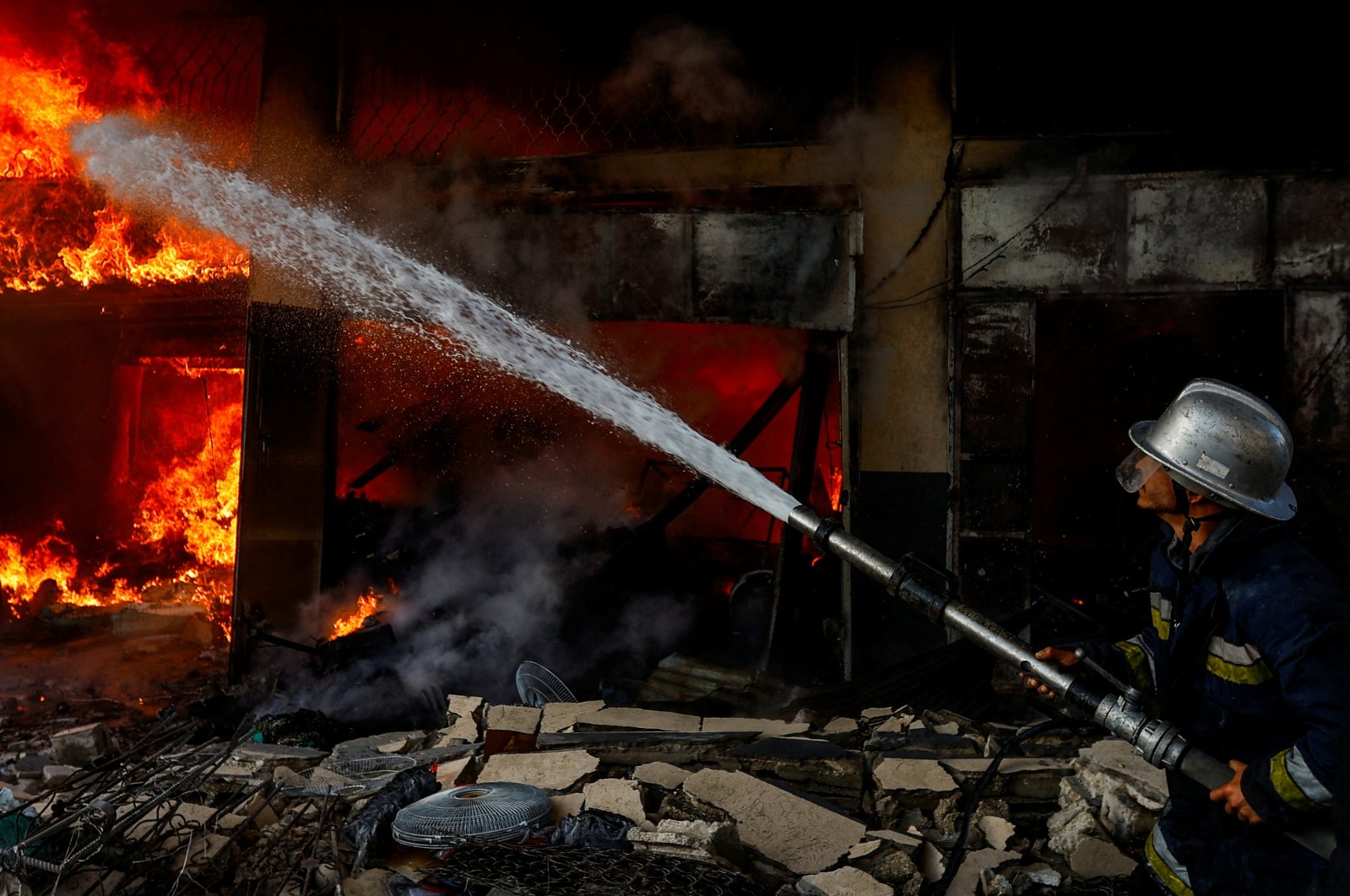 A Palestinian firefighter works to extinguish a fire in a house after an Israeli strike in Khan Younis, southern Gaza Strip, Palestine, Dec. 9, 2023. (Reuters Photo)