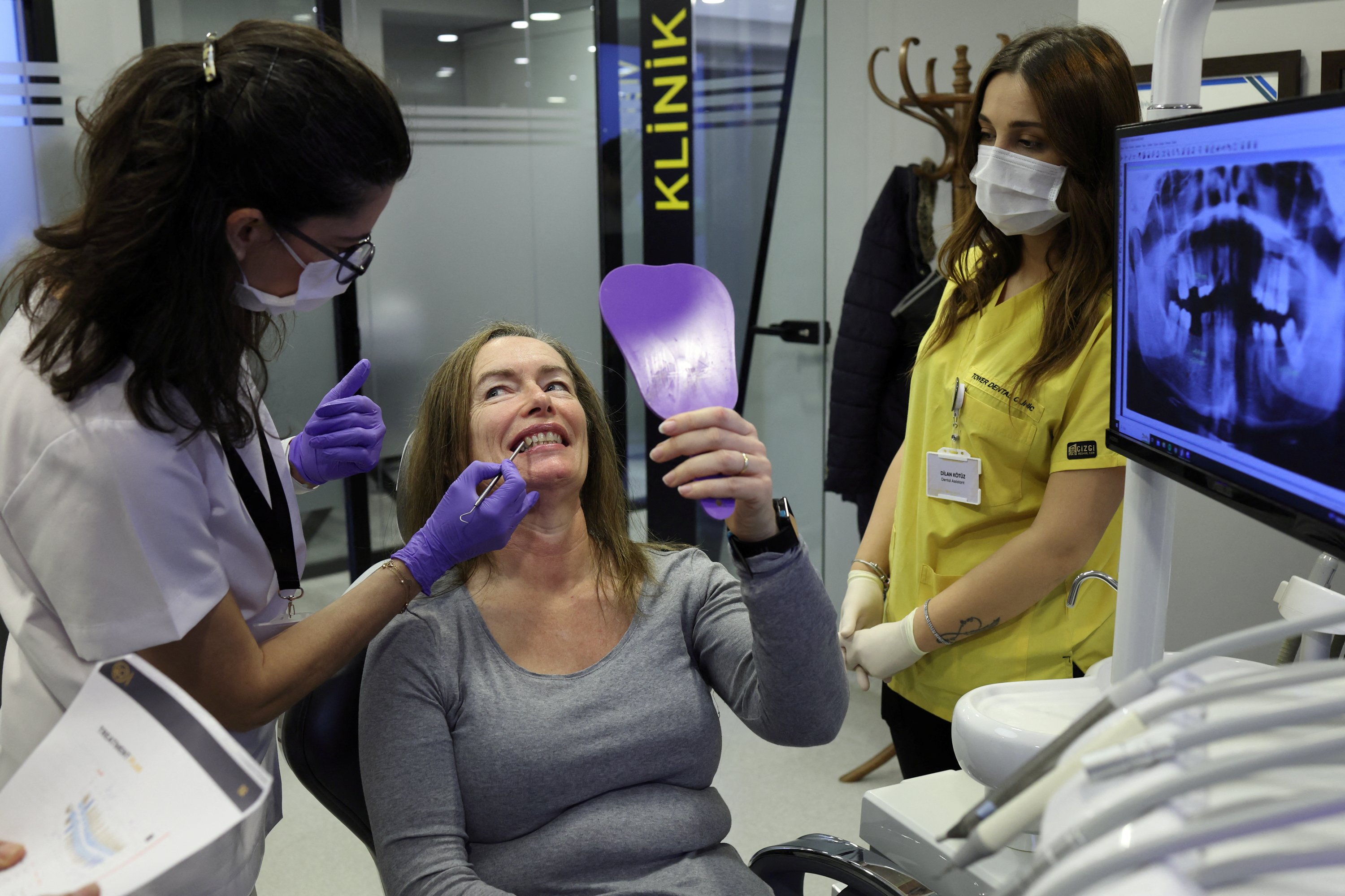 Turkish dentist Gamze Etemoğlu treats her patient Marion Parks, a 55-year-old British woman from a village near Ipswich, Suffolk, during a dental implant operation in Istanbul, Türkiye, Dec. 4, 2023. (Reuters Photo)