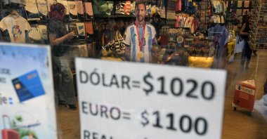 An image of Argentina&#039;s forward Lionel Messi is seen at a store displaying a sign with the exchange rate for U.S. dollars, euros and Brazilian reales in Argentine pesos, in Buenos Aires, Argentina, Nov. 21, 2023. (AFP Photo)