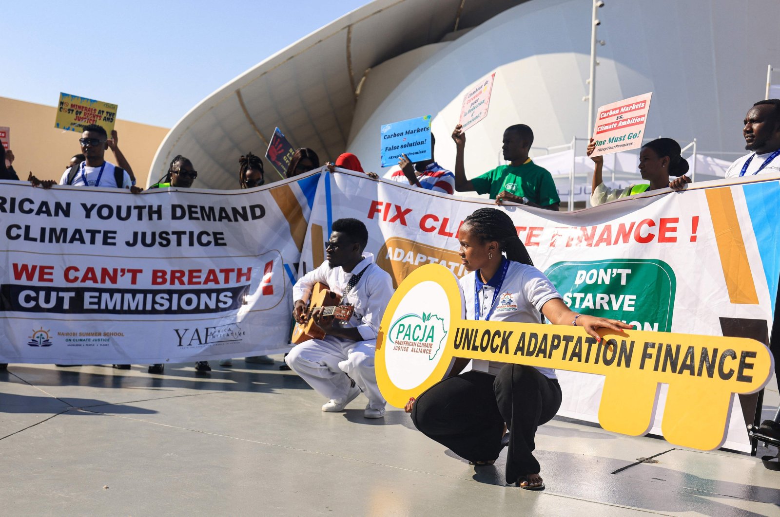 Environmental activists display placards during a demonstration at the venue of the COP28 United Nations climate summit in Dubai, United Arab Emirates, Dec. 6, 2023. (AFP Photo)