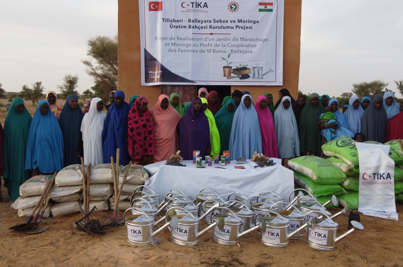 Officials from the Turkish Cooperation and Coordination Agency (TIKA) and locals stand near supplies for establishing a vegetable and Moringa garden, Niger, Dec. 11, 2023. (AA Photo)