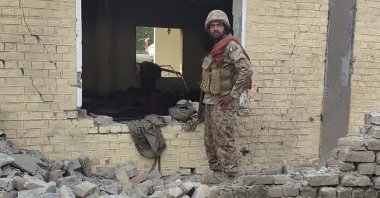 An army soldier examines damages on the site of a bombing, Dera Ismail Khan, Pakistan, Dec. 12, 2023. (AP Photo)