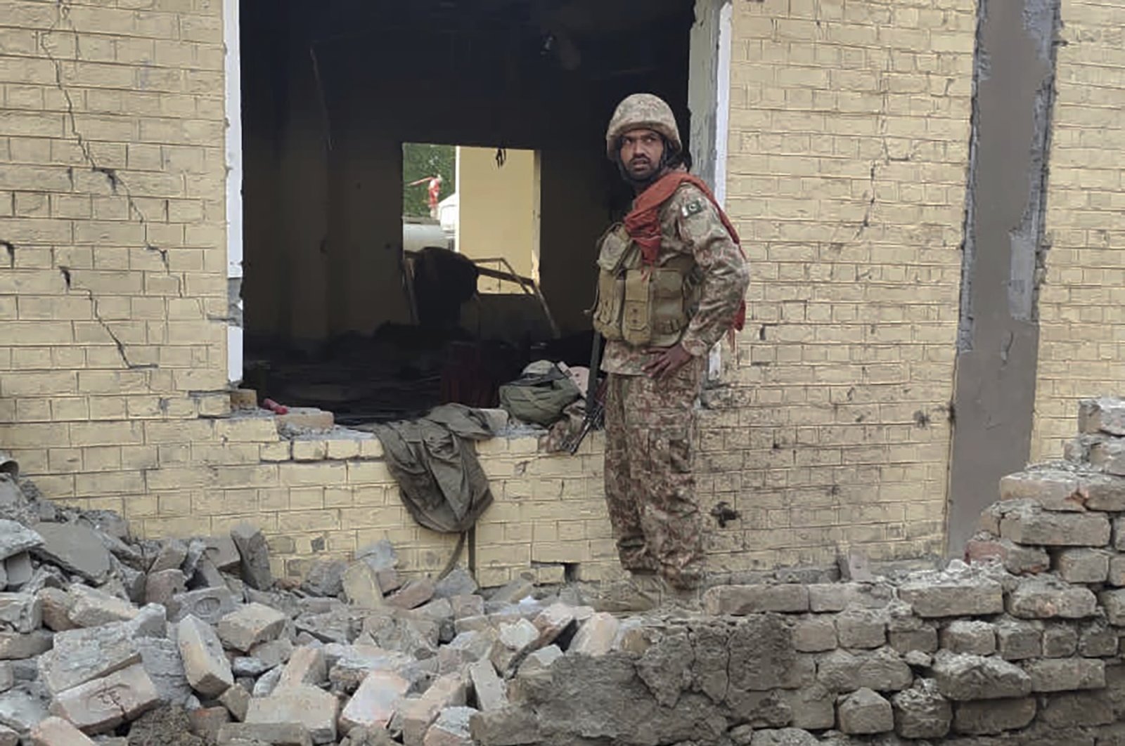 An army soldier examines damages on the site of a bombing, Dera Ismail Khan, Pakistan, Dec. 12, 2023. (AP Photo)