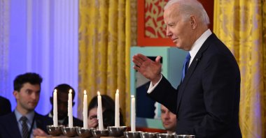 U.S. President Joe Biden waves as he walks by the Menorah during a Hanukkah reception in the White House, Washington, D.C., Dec. 11, 2023. (AFP Photo)
