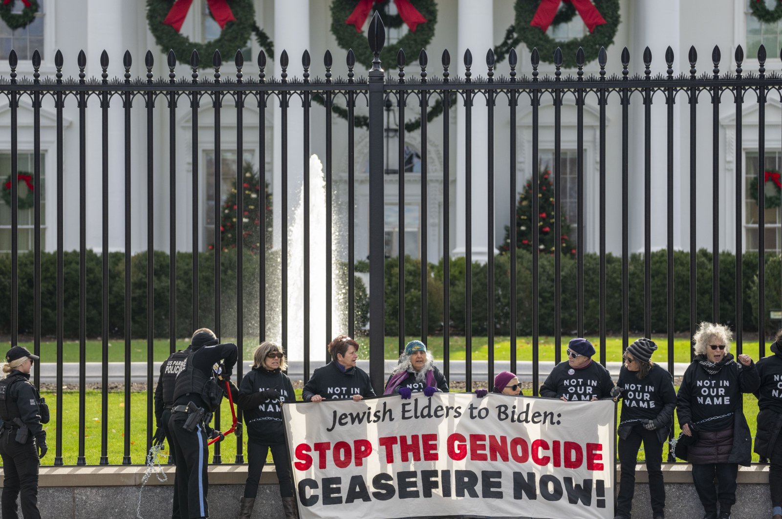 U.S. Park Police officers use bolt cutters on a chain as activists with Jewish Voice for Peace, gather to protest the Israel-Hamas war in Gaza and chain themselves to the fence outside the White House, in Washington, U.S., Dec. 11, 2023. (AP Photo)