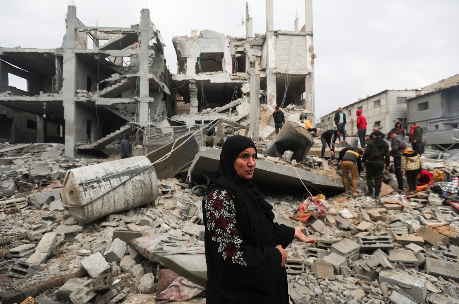 A Palestinian woman reacts as people inspect the site of Israeli strikes on houses, Khan Younis, southern Gaza Strip, Palestine, Dec. 14, 2023. (Reuters Photo)