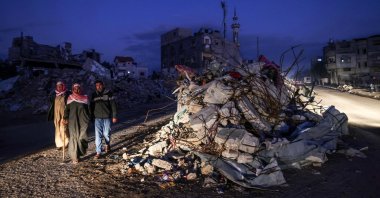 Palestinians walk past the rubble of buildings destroyed by Israeli bombardment, Rafah, southern Gaza Strip, Palestine, Dec. 15, 2023. (AFP Photo)