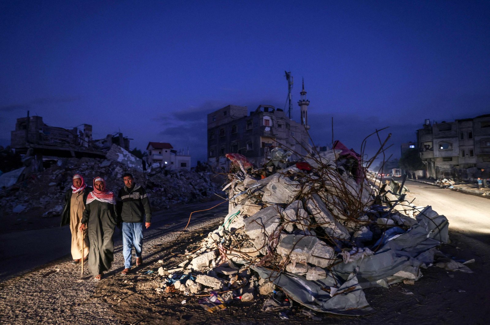 Palestinians walk past the rubble of buildings destroyed by Israeli bombardment, Rafah, southern Gaza Strip, Palestine, Dec. 15, 2023. (AFP Photo)