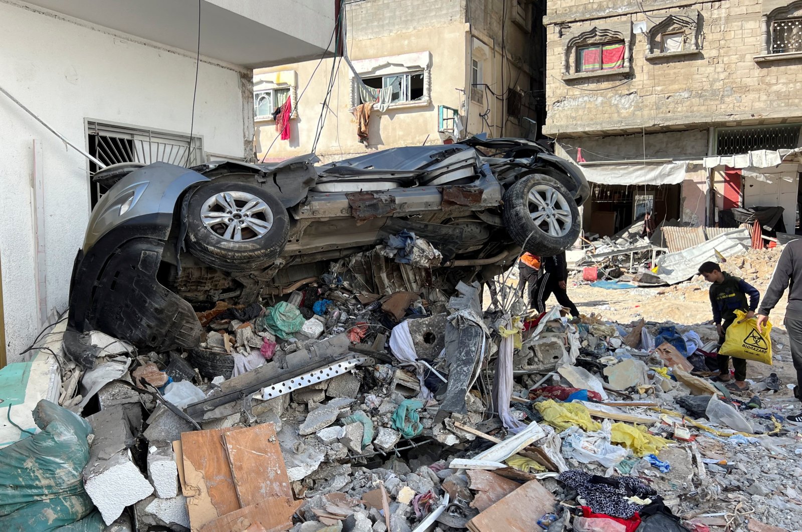 A damaged car sits on rubble following an Israeli raid at Kamal Adwan hospital in the northern Gaza Strip, Palestine, Dec. 16, 2023. (Reuters Photo)
