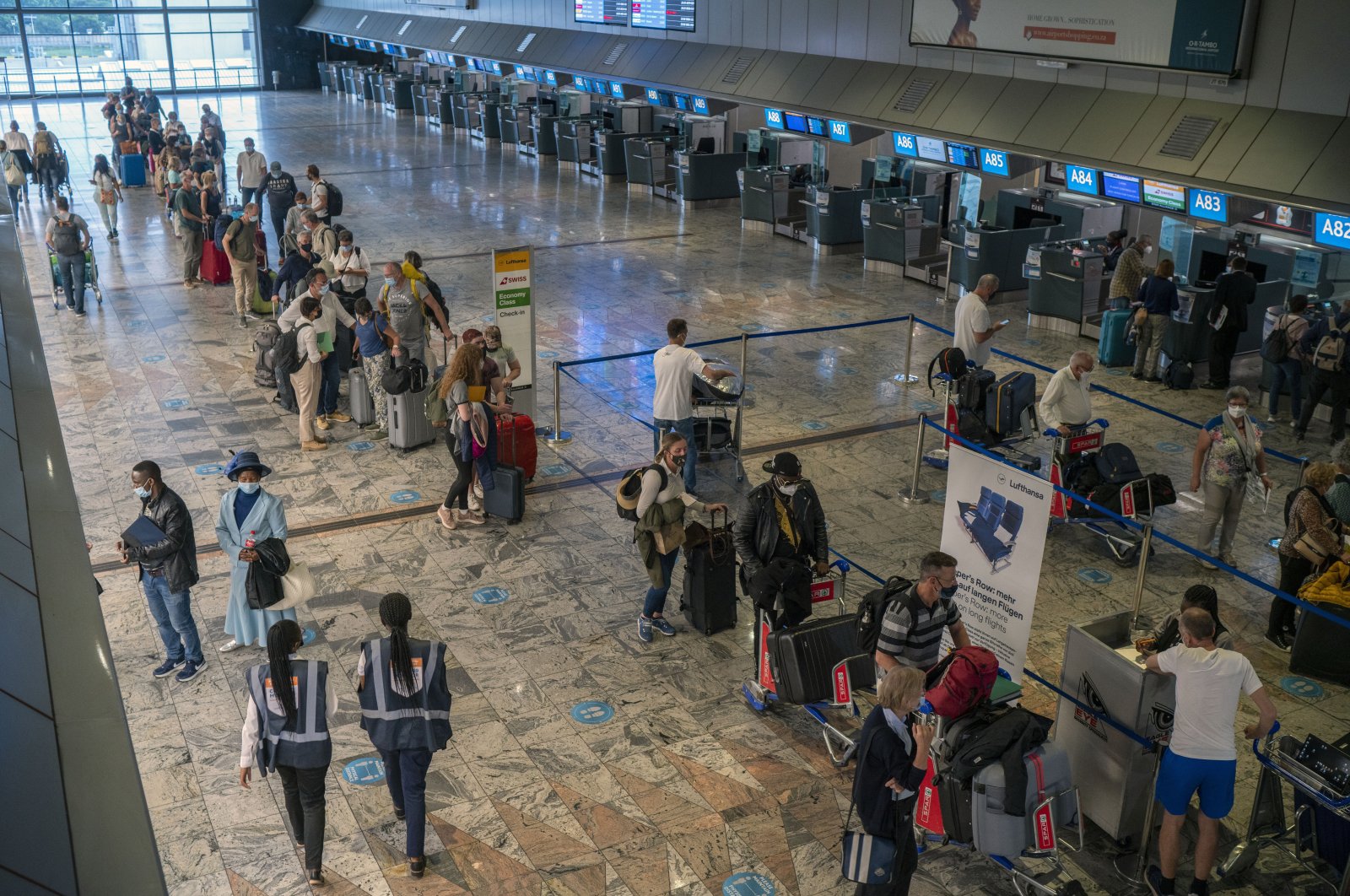 Passengers check in at a counter at Johannesburg&#039;s OR Tambo International Airport, South Africa, Nov. 29, 2021. (AP Photo)