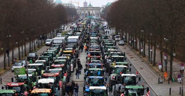 People walk beside tractors, as German farmers take part in a protest against the cut of vehicle tax subsidies, near the Brandenburg Gate in Berlin, Germany, Dec. 18, 2023. (Reuters Photo)
