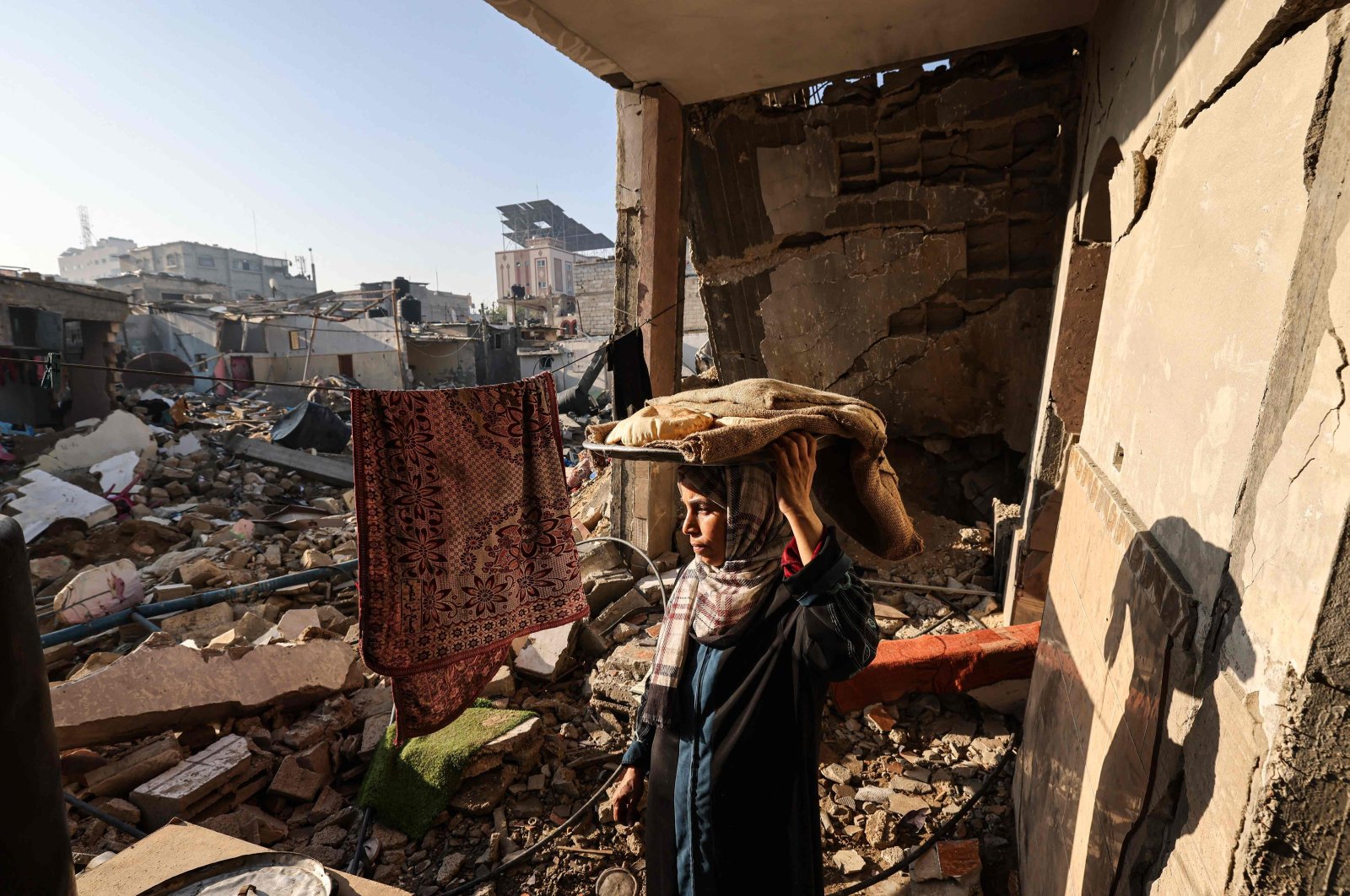 A woman carries bread in her destroyed house in Rafah, southern Gaza Strip, Palestine, Dec. 18, 2023. (AFP Photo)
