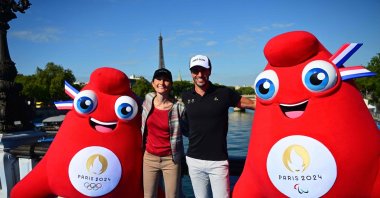 Olympic Phryges mascots pose for a photograph with French Sports Minister Amelie Oudea-Castera (L) and Paris 2024 Olympics President Tony Estanguet on the Alexandre III bridge with the Eiffel Tower in the background after the mixed relay and last day of the 2023 World Triathlon-duathlon format of the Olympic Games Test Event, Paris, France, Aug. 20, 2023. (AFP Photo)